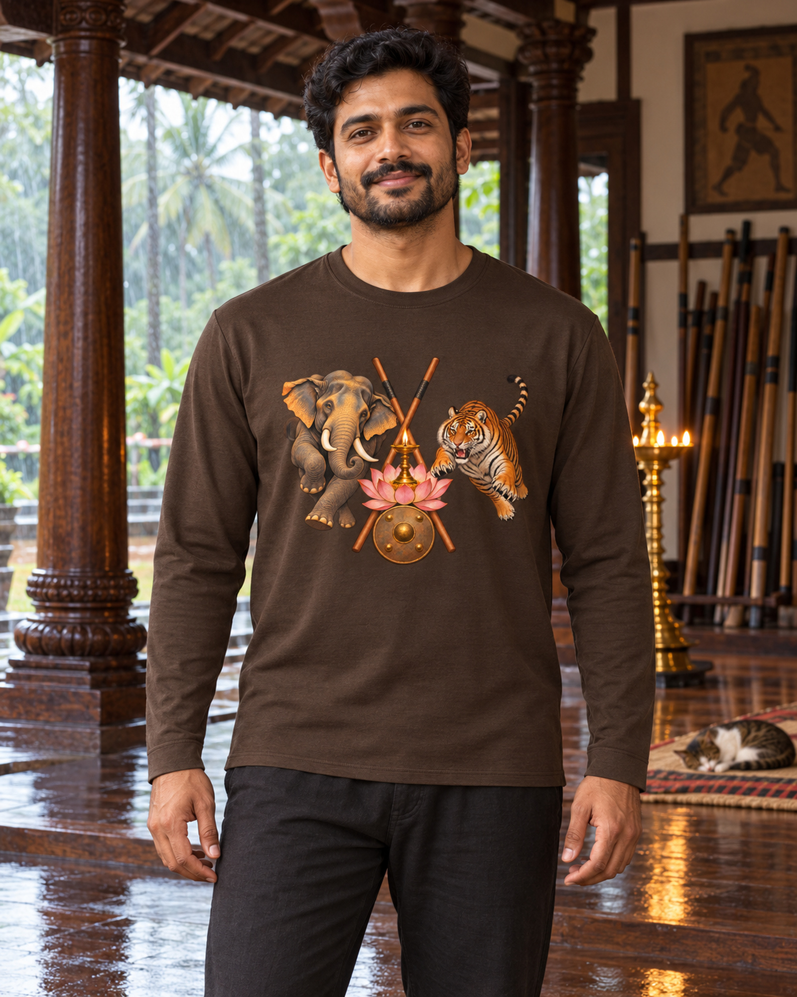 Mann im braunen Kalari-Langarmshirt in einer Holzhalle mit Blick auf den Monsunregen.