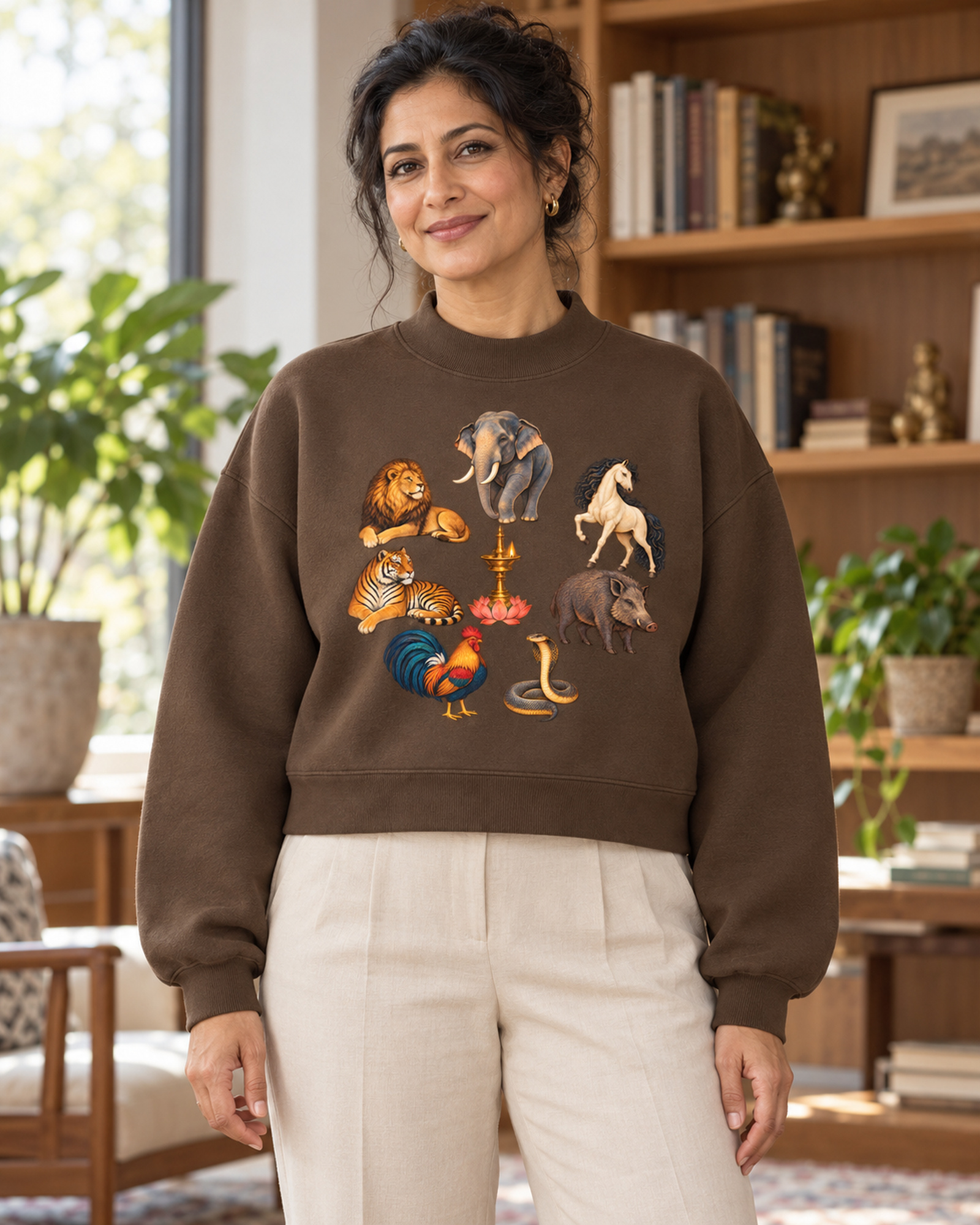 Frau mit braunem Damen-Fleece und Kalari-A-Motiv in einem warmen Leseraum.